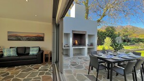 A living room with a stone floor, a black sofa, and a fireplace.