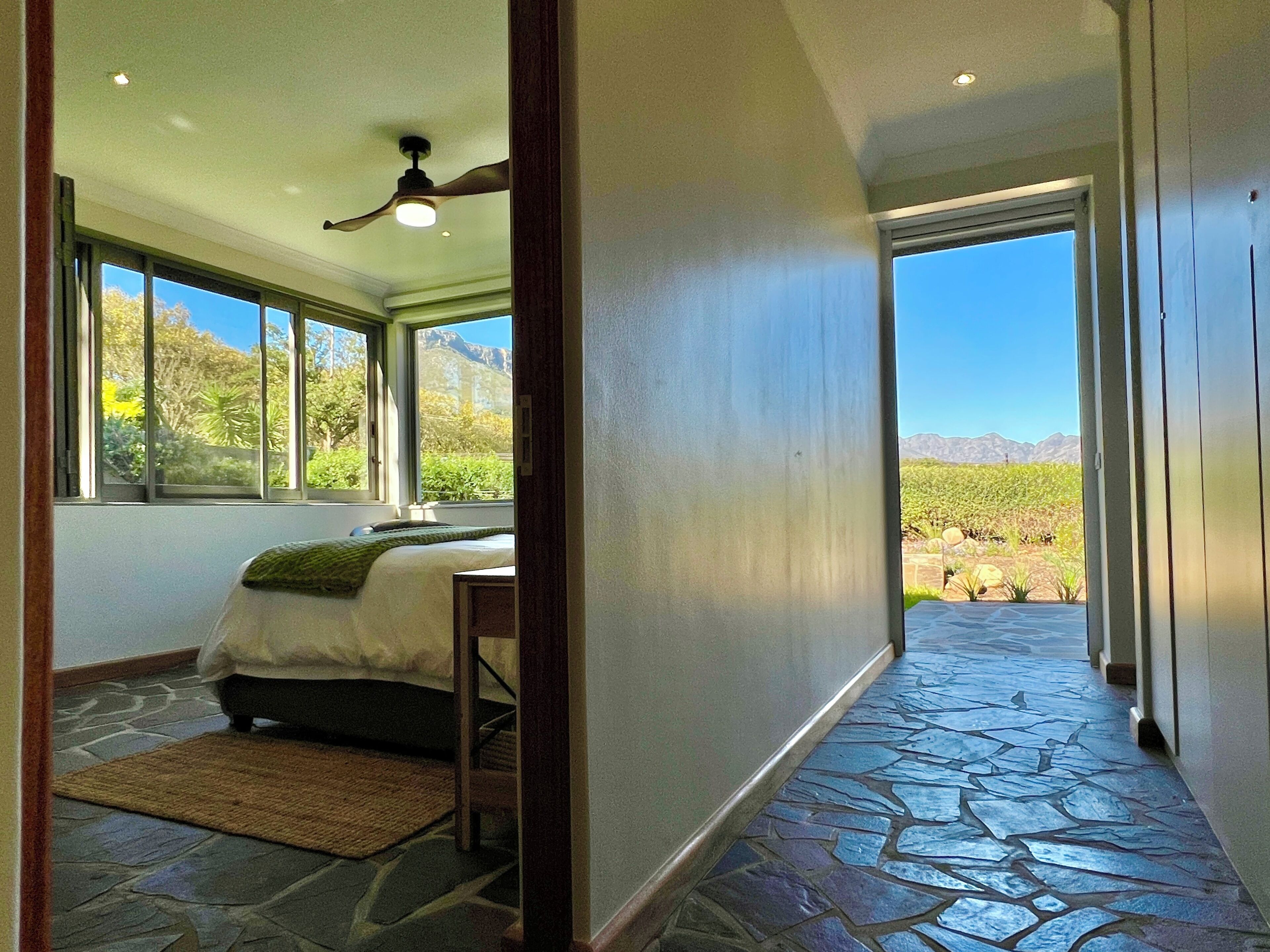 A bedroom with a bed, a window, and a view of a mountainous landscape.