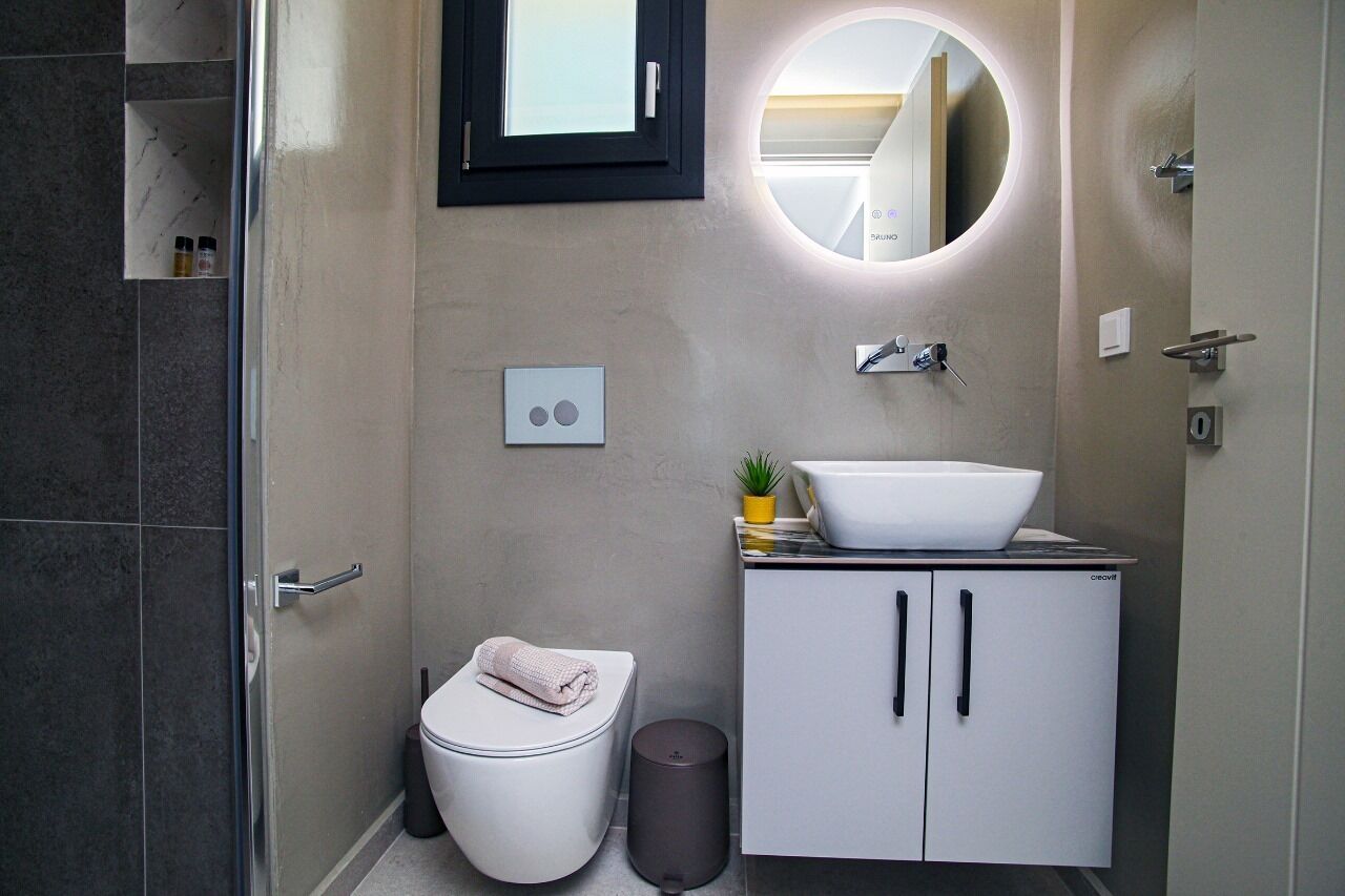 Un baño moderno con inodoro, bidé, lavabo, espejo y mueble.
