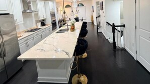 A modern kitchen with a central island, stainless steel appliances, and pendant lighting.