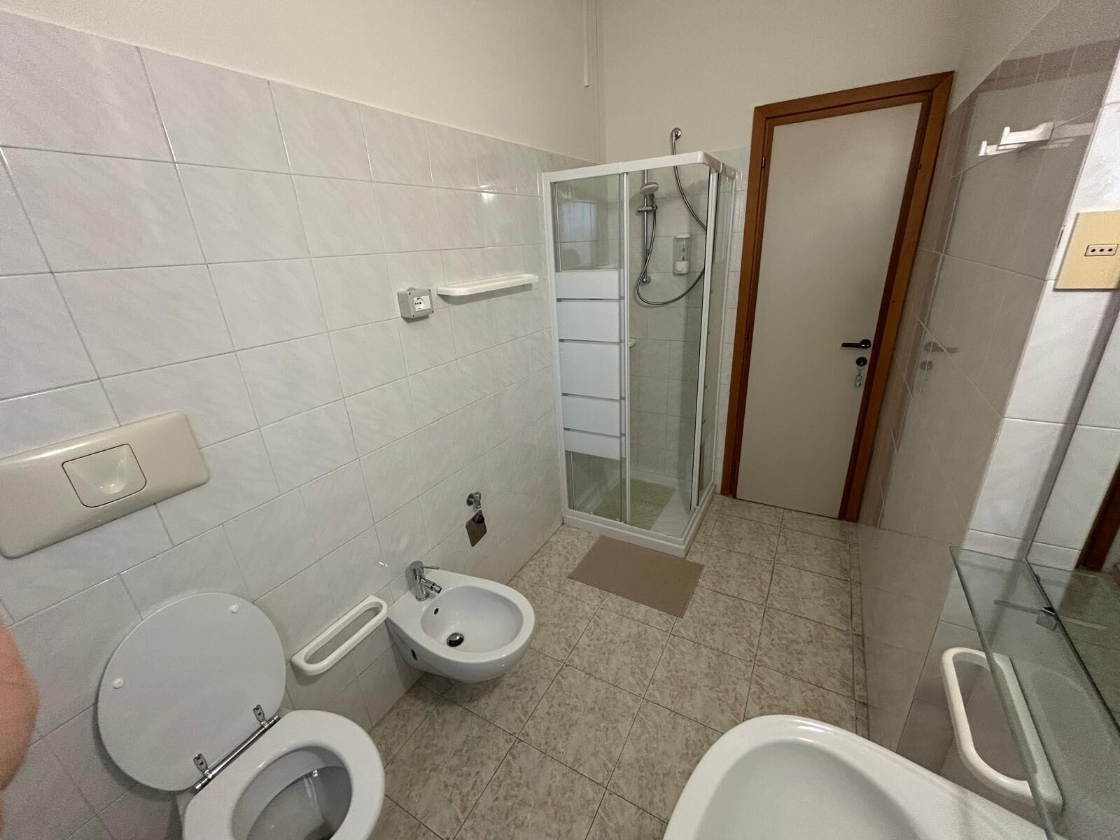 Une salle de bain équipée de toilettes, d’un bidet et d’une douche.