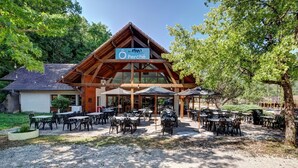 A restaurant with outdoor seating, a wooden facade, and a sign that reads "Perché".