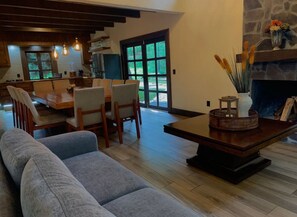 Ein modernes Wohnzimmer mit einer Couch, einem Esstisch, Stühlen und einem Kamin.
