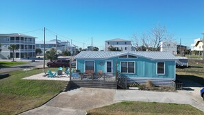 A small, single-story building with a porch and outdoor seating area. - STEPS TO THE BEACH
WELCOME TO PARADISE (Mexico Beach)