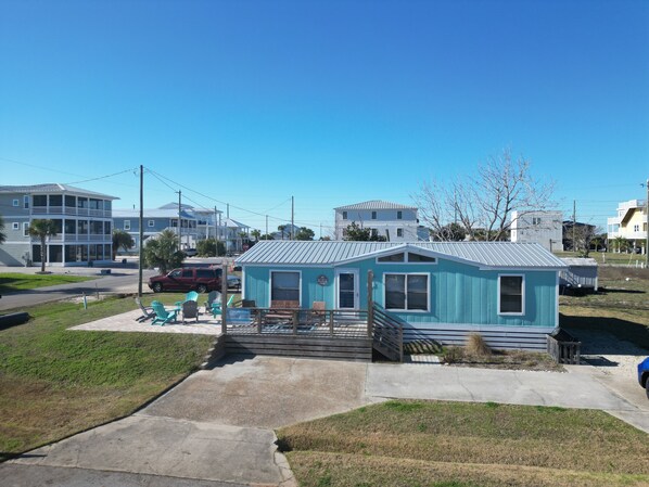 A small, single-story building with a porch and outdoor seating area.