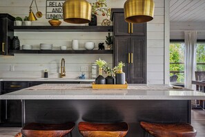 A kitchen with a large island, dark wooden cabinets, and gold pendant lights. - New Listing! Views, Game Rm, Theater, Fire Pit! (Gatlinburg)