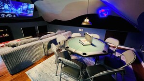 A room with a large flat-screen TV, a round table with chairs, a sofa, and a patterned rug. - One-of-a-kind historic getaway, where timeless charm meets modern fun & comfort. (Front Royal)