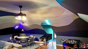 A room with a foosball table, a desk with a computer, and a couch. - One-of-a-kind historic getaway, where timeless charm meets modern fun & comfort. (Front Royal)