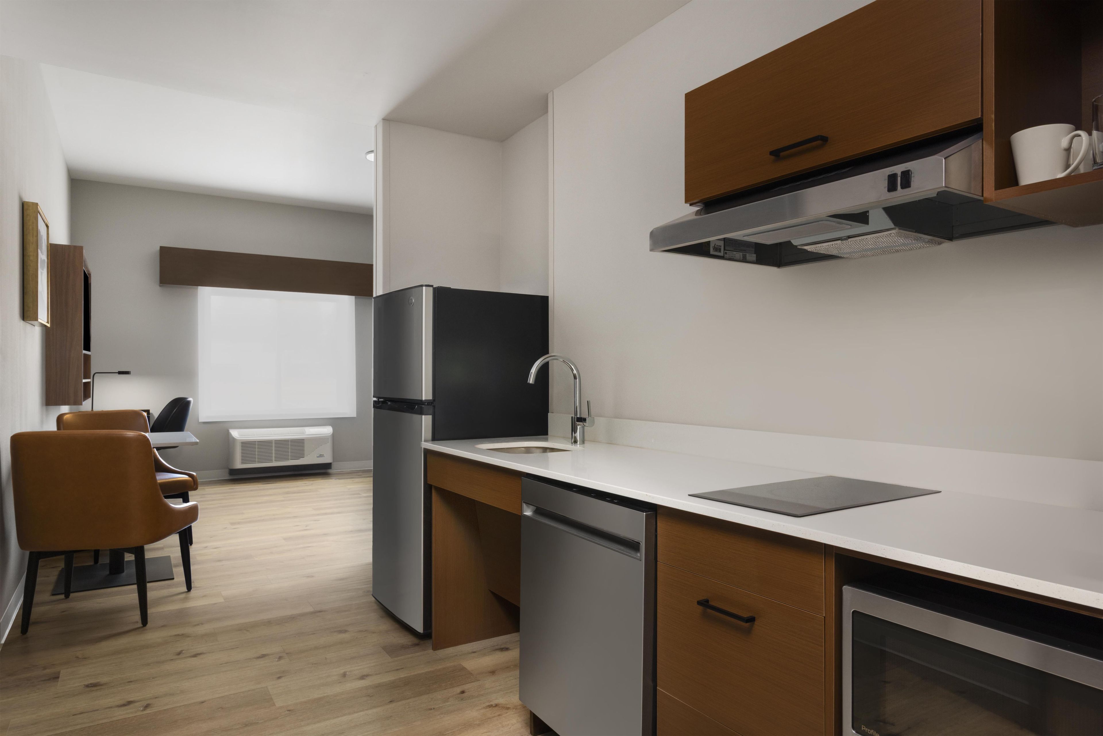A modern kitchen with a built-in dishwasher, a stainless steel refrigerator, and a microwave.