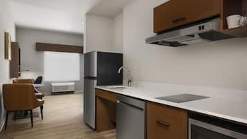 A modern kitchen with a built-in dishwasher, a stainless steel refrigerator, and a microwave.