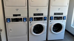 A row of stacked laundry machines in a commercial setting. - @HOME by Best Western McDonough Atlanta South (McDonough)