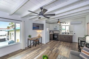 Ein geräumiger Wohnbereich mit Esstisch, Sofa und Deckenventilator.