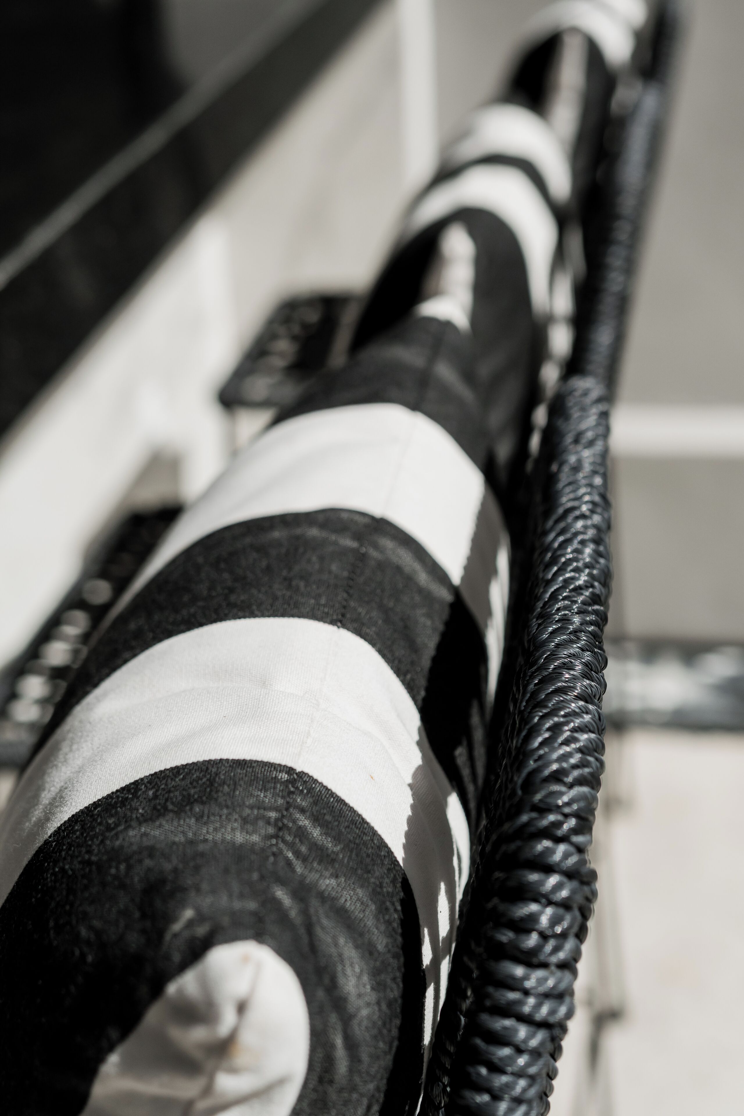 A close-up of a black and white striped fabric, possibly a part of a piece of furniture or decor.