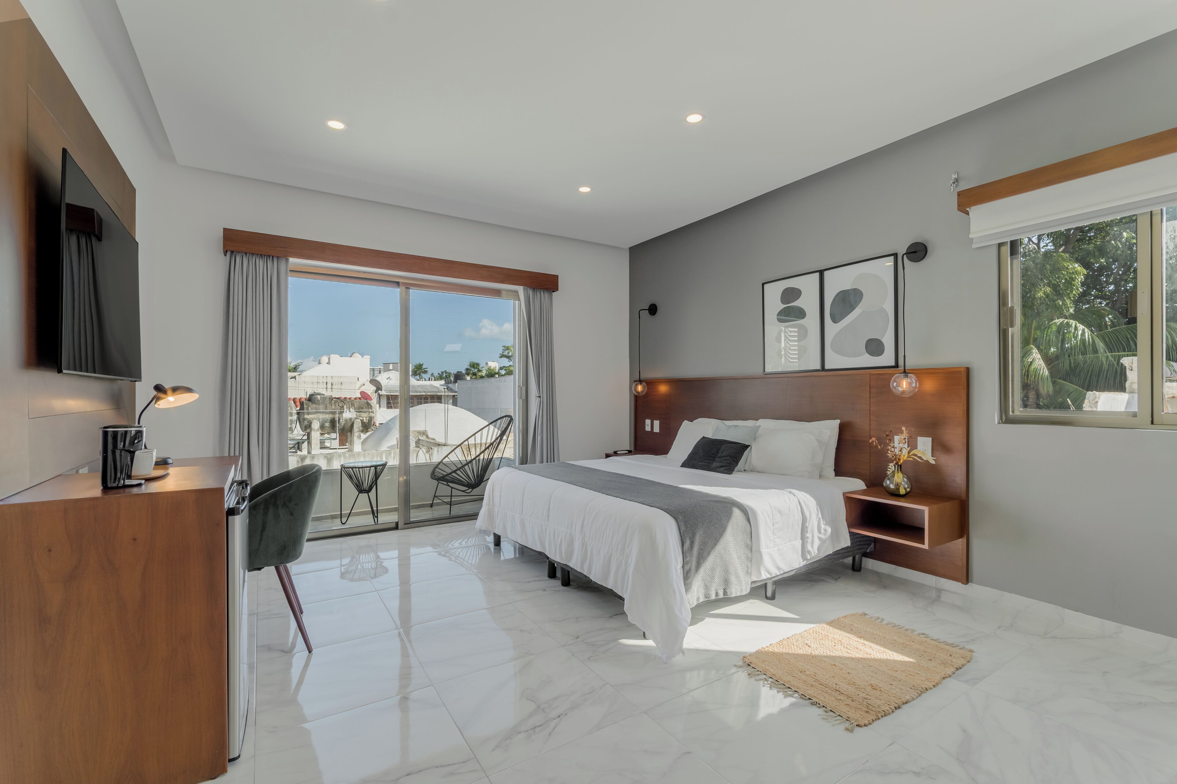 Un dormitorio moderno con cama, mesita de noche y televisor.