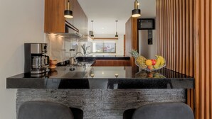 A modern kitchen with a central island, stainless steel appliances, and wooden accents.