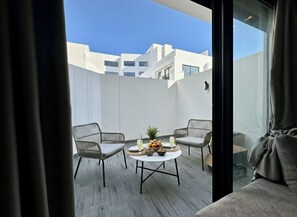 Un balcone con un tavolo rotondo, due sedie e vista sugli edifici.