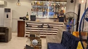 Una sala de estar moderna con un sofá, una mesita de centro y una zona de bar al fondo.