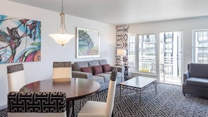 Uma sala de estar moderna com um sofá, uma mesa de jantar e um tapete estampado.