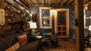 A cozy room with a wooden ceiling, a rocking chair, a sofa, and a lamp. - Lovely 2-bedroom waterfront cottage with many outdoor activities and charm (Foley)