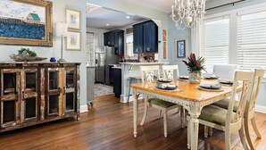 Un coin repas avec une table en bois, des chaises et un lustre.