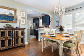 A dining area with a wooden table, chairs, and a chandelier. - Lovely 2-bedroom waterfront cottage with many outdoor activities and charm (Foley)