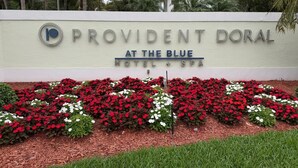 Cartell del Provident Doral Hotel & Spa amb un arranjament floral a la part frontal.