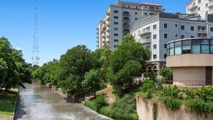 Un río atraviesa una zona residencial con edificios modernos y áreas verdes.