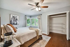 A bedroom with a bed, a ceiling fan, a window with curtains, and a closet. - Spacious 4BR + 3.5BA Home, Backyard, Tampa & USF (Lutz)