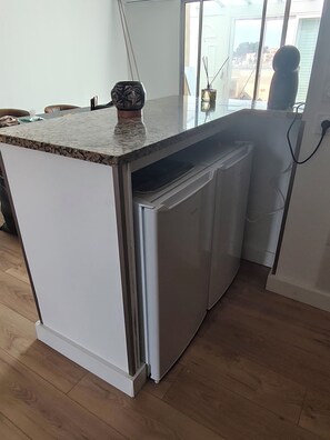 Eine Küche mit integriertem Kühlschrank, einer Arbeitsplatte und einem Fenster mit Blick ins Freie.