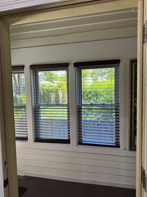 A room with three windows, a door, and a carpeted entrance. - apartment with alarge outdoor entertaintment area in charming downtown Saugatuck (Saugatuck)
