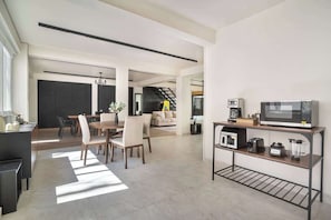 A modern kitchen with a microwave, toaster, and blender on a metal stand.