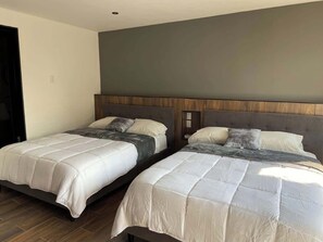 Two beds with headboards, a wooden floor, and a dark-colored wall. - Prime Polanco 5BR Apt Near Masaryk (Mexico City)