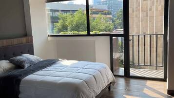 Een slaapkamer met een groot raam, een bed en een balkon.
