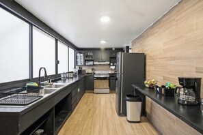 A modern kitchen with a central island, a built-in oven, a refrigerator, and a coffee maker. - Polanco Stay, Terrace, Workspace & Prime Location (Mexico City)