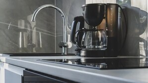 Eine moderne Küche mit Kaffeemaschine, Wasserhahn und Wasserkocher.