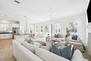 A spacious living area with a large sofa, a coffee table, and a fireplace. - NEW! 30A Chic 6 King Bedroom Showstopper! Sleeps 17! Seacrest Beach! HUGE POOL! (Inlet Beach)