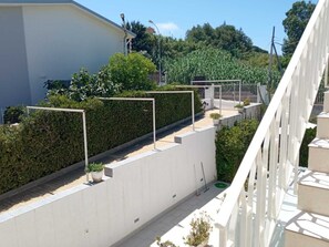 Ein Wohngebiet mit einem weißen Gebäude, einer Hecke und einer Treppe.
