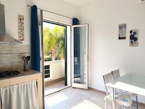 Eine moderne Küche mit Gaskochfeld, einer Kaffeemaschine und einem Fenster mit Blick auf Grünflächen.
