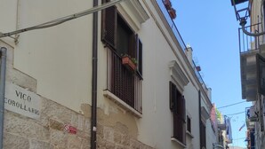 Una calle estrecha con escalones de piedra, un letrero que dice 'VICO COROLLARIO' y una señal de no estacionamiento.