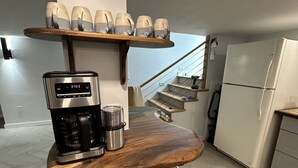 A modern kitchen with a built-in coffee maker, a stainless steel trash bin, and a white refrigerator. - Short walk to downtown & Flathead Lake (Polson)