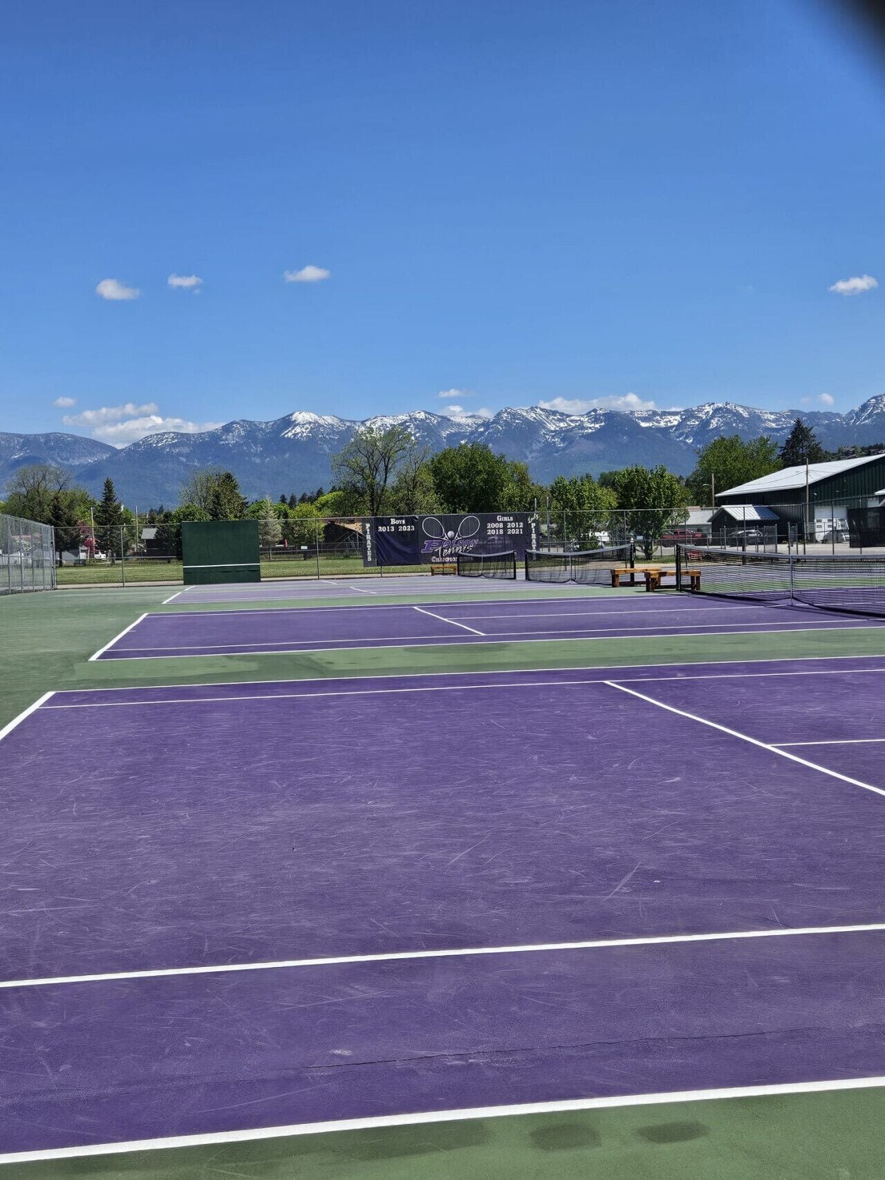 Un court de tennis avec une chaîne de montagnes en arrière-plan.