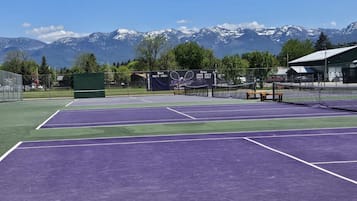 Un court de tennis avec une chaîne de montagnes en arrière-plan.