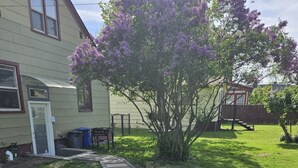 A pathway leading to a house with a small tree and a barbecue grill in the yard. - Short walk to downtown & Flathead Lake (Polson)