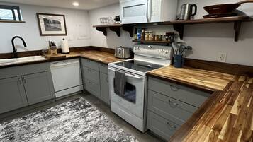 Une cuisine équipée d’une cuisinière, d’un four à micro-ondes et de plans de travail en bois.