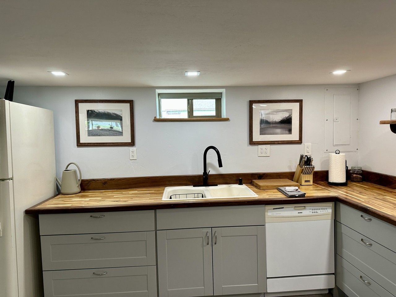 A kitchen with a built-in dishwasher, a sink, and wooden countertops.