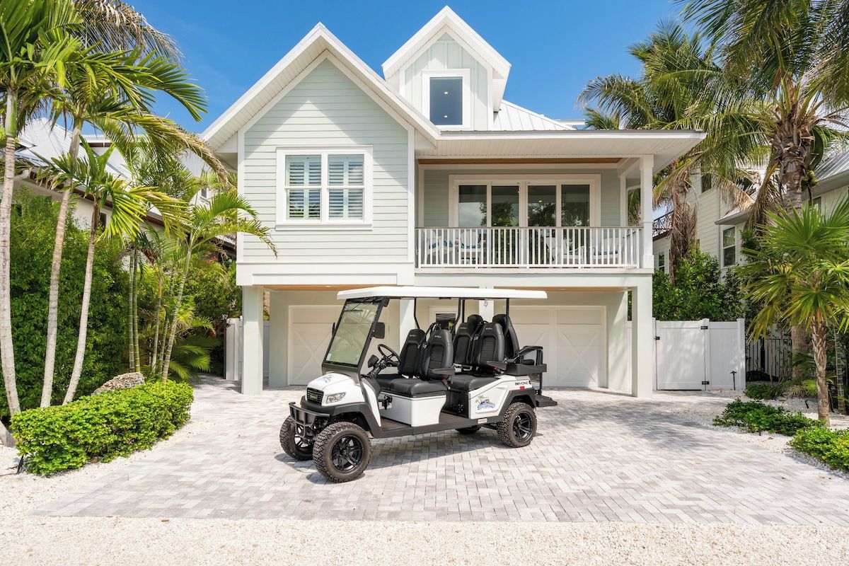 A two-story house with a garage and a golf cart parked in front.