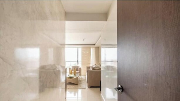A modern interior with a marble floor, a wooden door, and a living area with a sofa and coffee table. - Luxo no Vale do Lili (Cali)