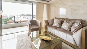 A modern living room with a glass coffee table, a sofa, and a chair. - Luxo no Vale do Lili (Cali)