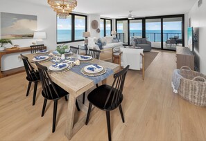 A dining area with a wooden table set for six, surrounded by black chairs. - 17th-Floor Gulf View Condo | Heated Pool, Hot Tub (Panama City Beach)