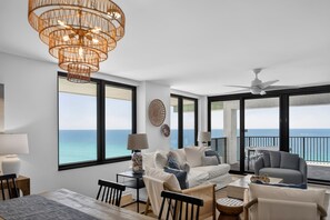 A spacious living area with a large window overlooking the ocean, a ceiling fan, and a dining area with a table and chairs. - Panoramic View, Free Beach Chairs (Panama)